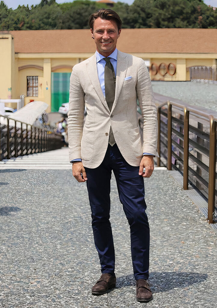 Beige blazer, light blue shirt, navy pants, and brown suede monk straps