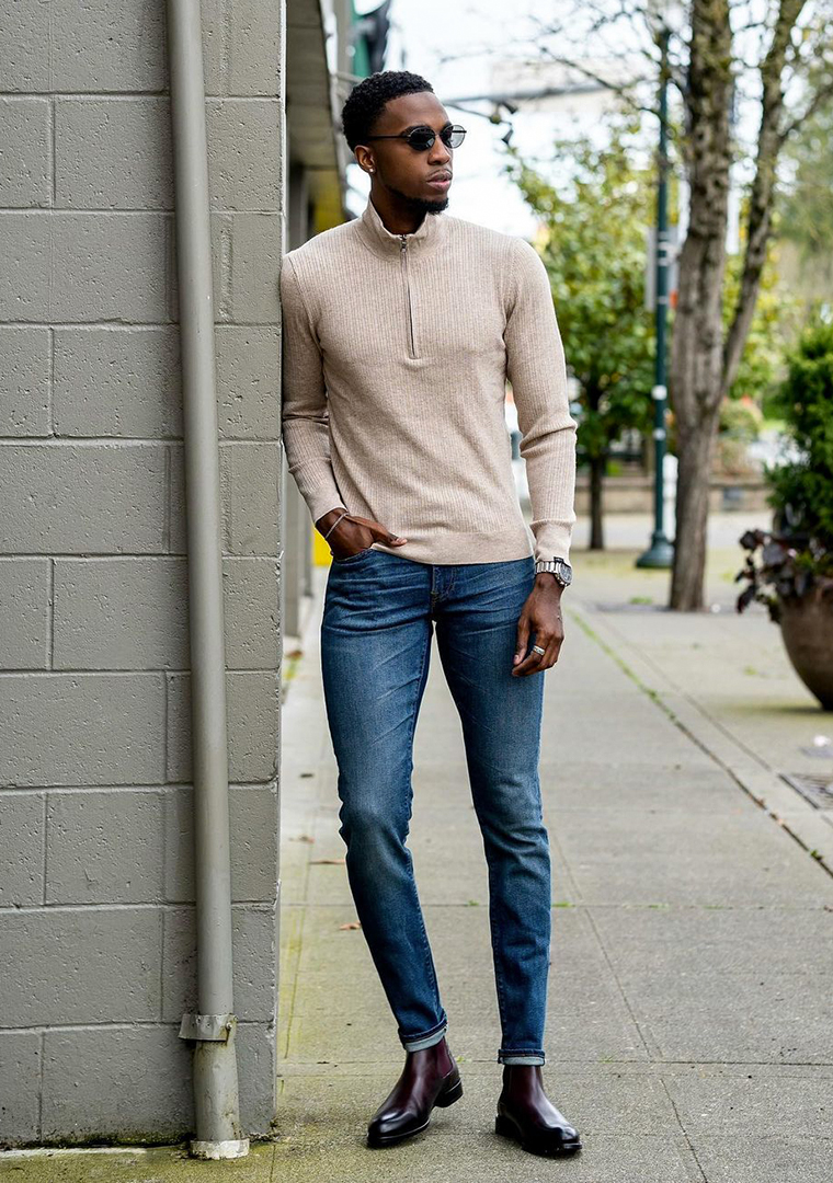 Beige zip-neck sweater, blue jeans, and burgundy Chelsea boots