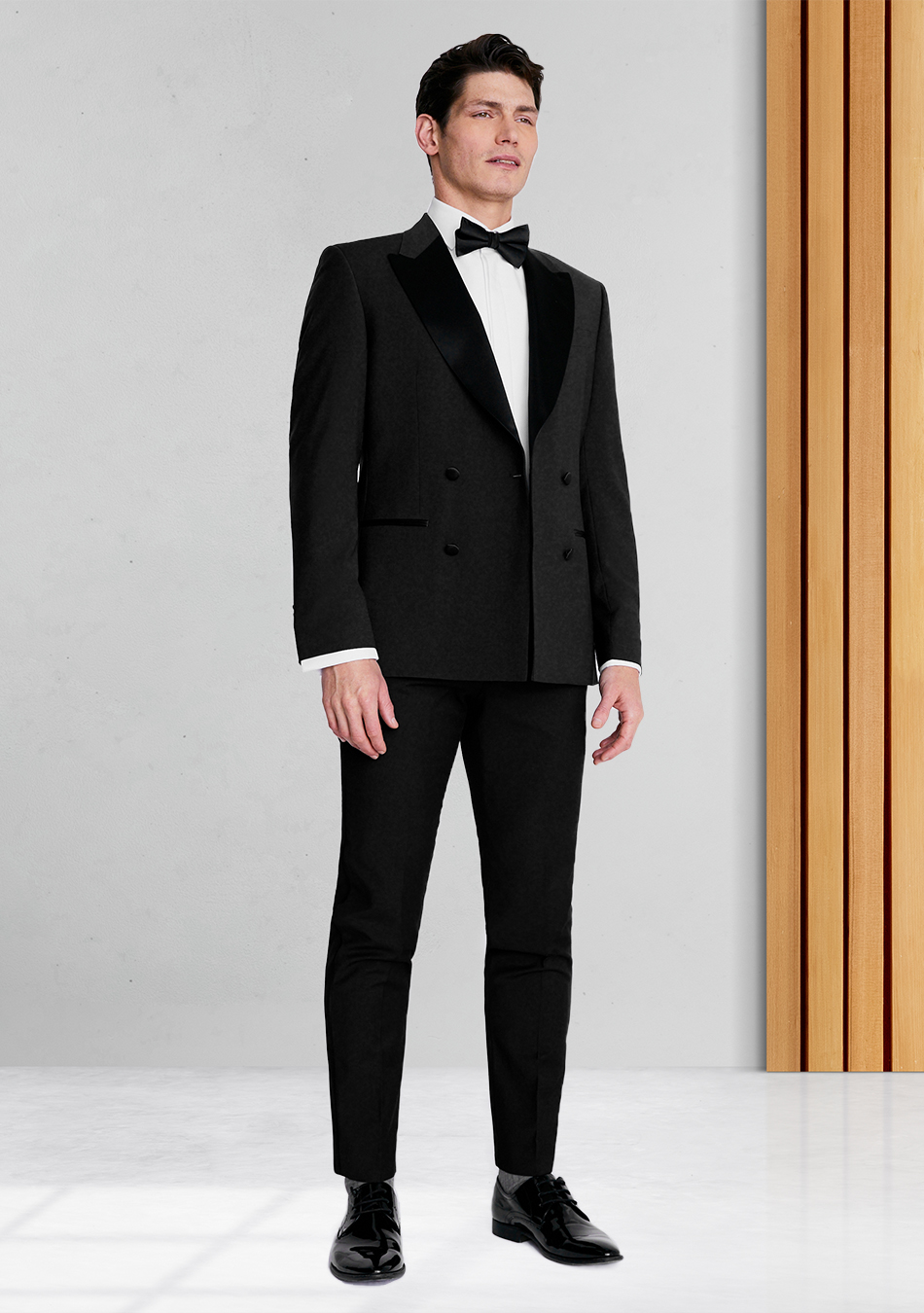 Black double-breasted tuxedo, white shirt, black bow tie, and black derby shoes