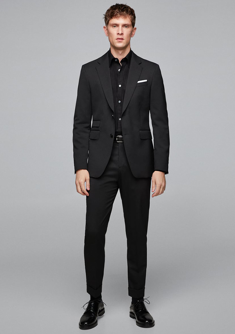 Black suit, black dress shirt, and black derby shoes