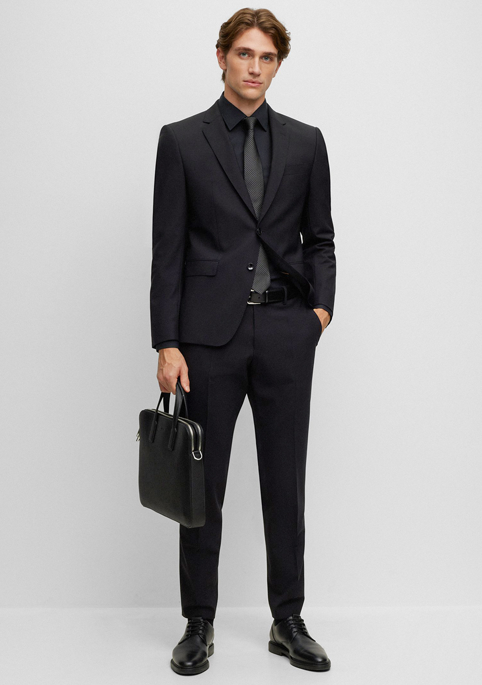 Black suit, black dress shirt, black dotted tie, and black derby shoes