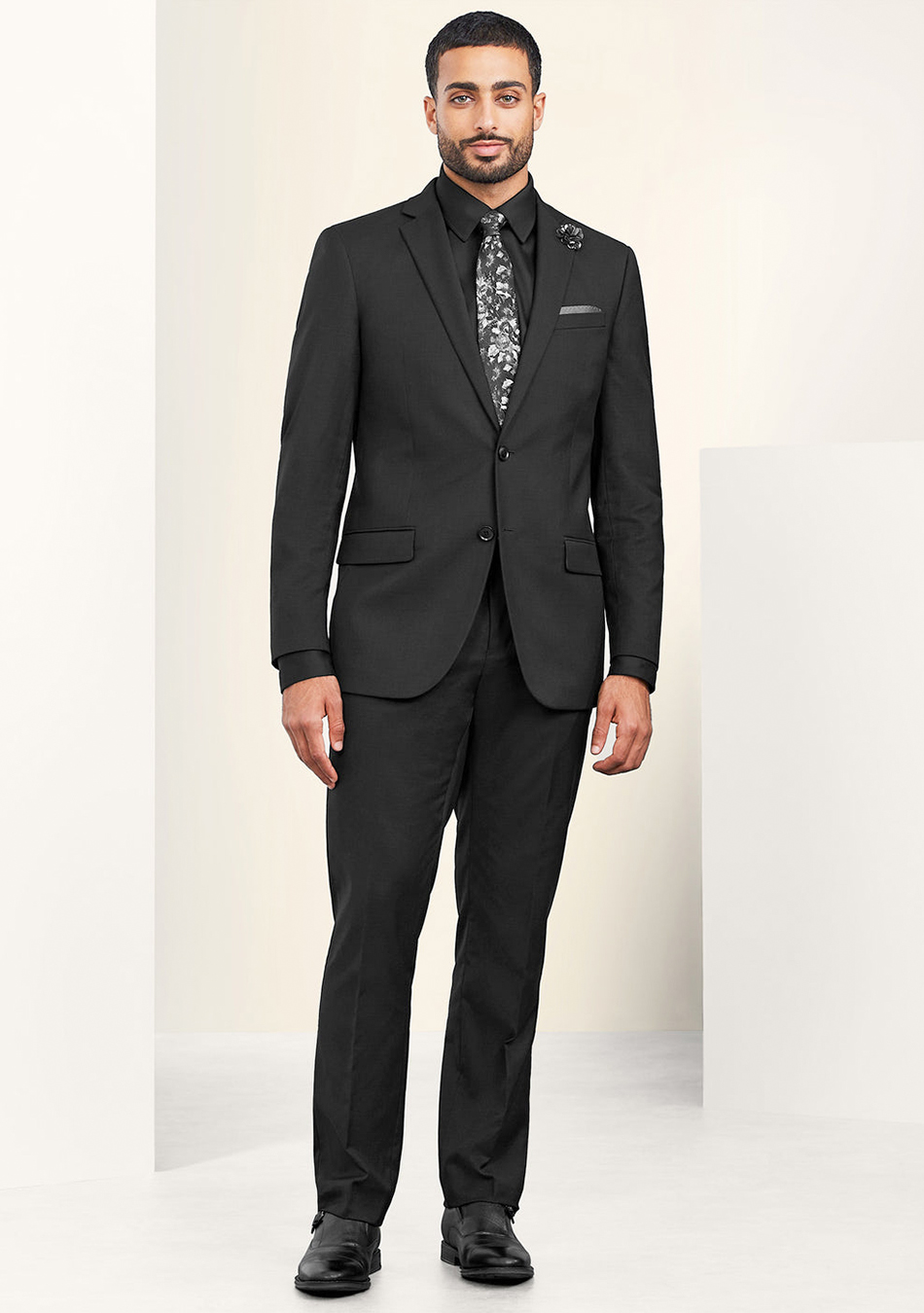 Black suit, black shirt, floral tie, and black dress shoes