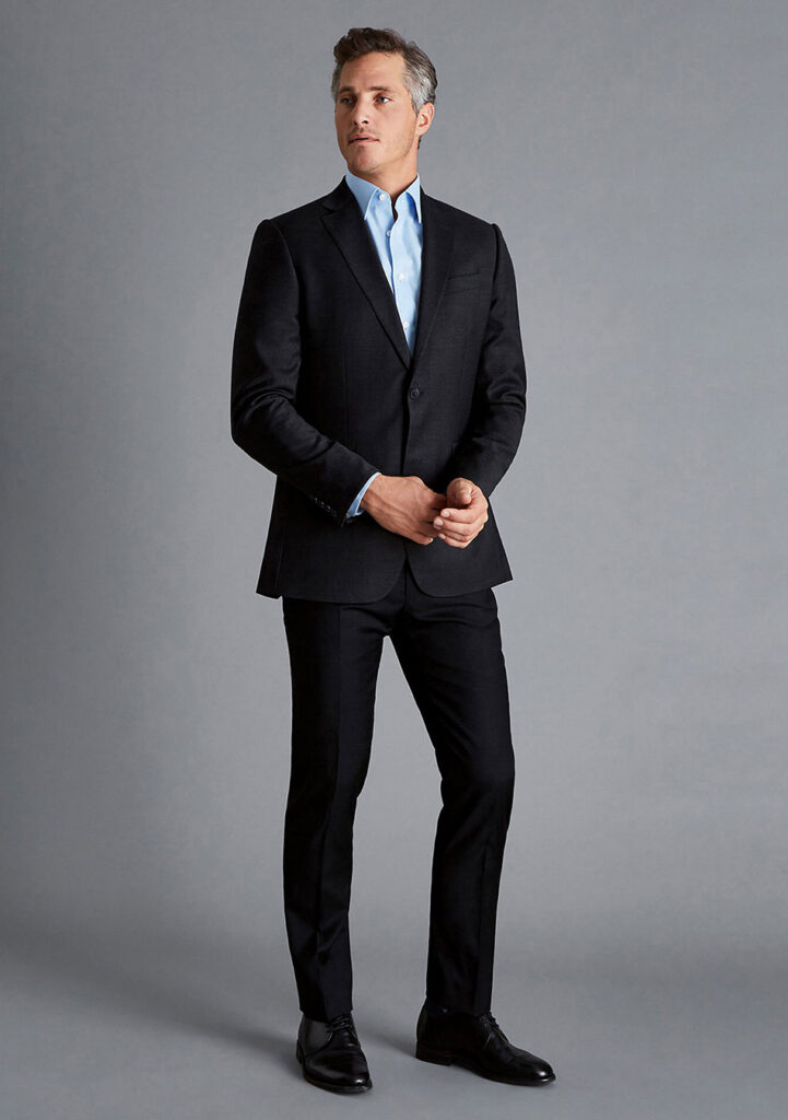 Black suit, blue dress shirt, and black derby shoes