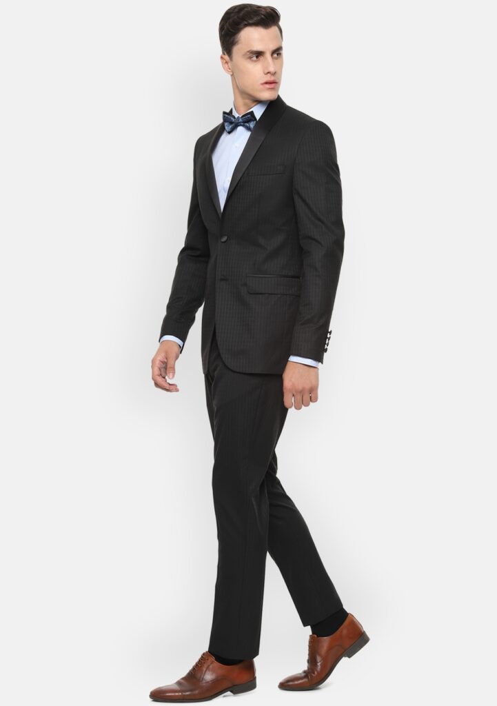 Black suit, blue shirt, navy bow tie, and brown shoes