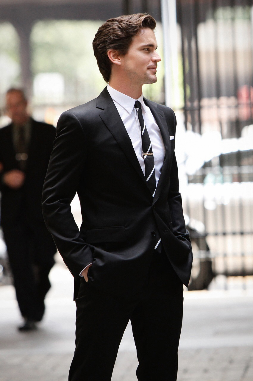 Slim-fit black suit, white shirt, and white/black striped tie