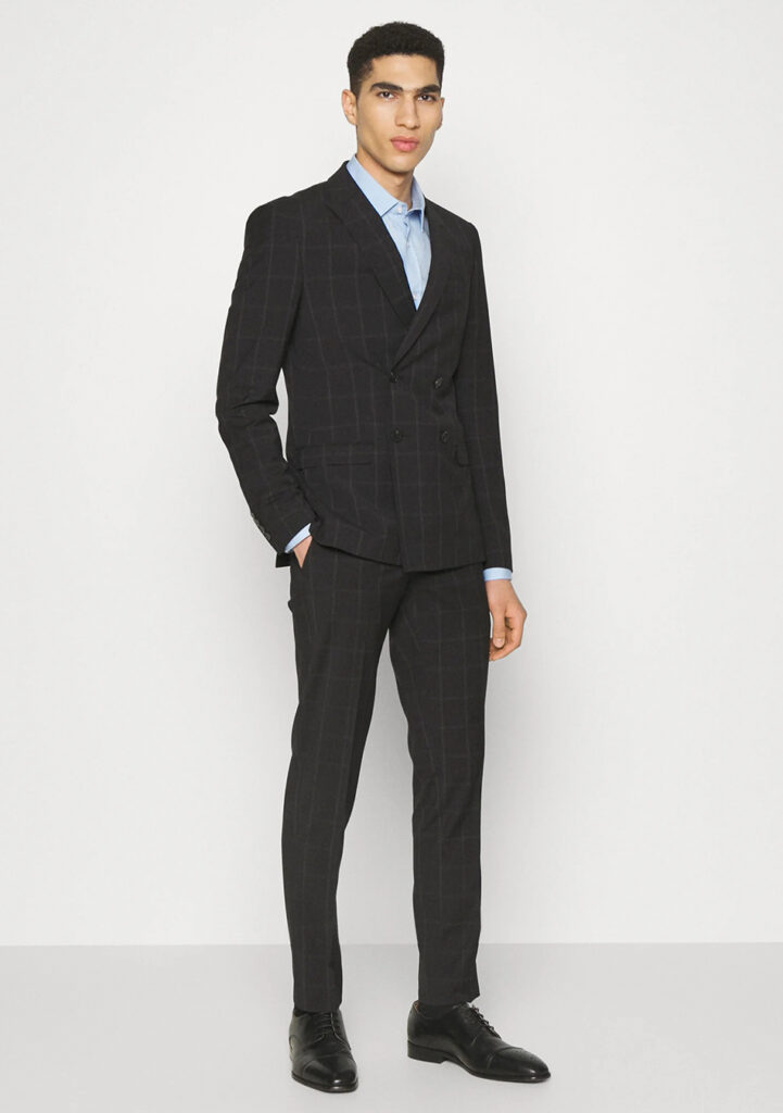 Windowpane double-breasted suit, blue shirt, and black derby shoes