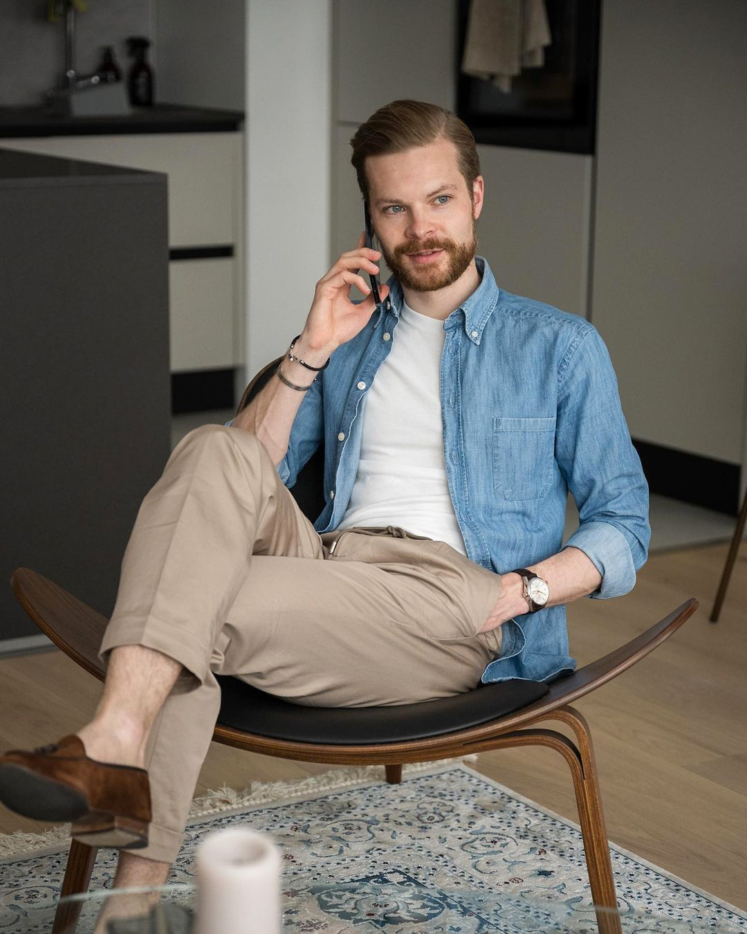 Blue denim shirt, white t-shirt, khaki pants, and brown loafers