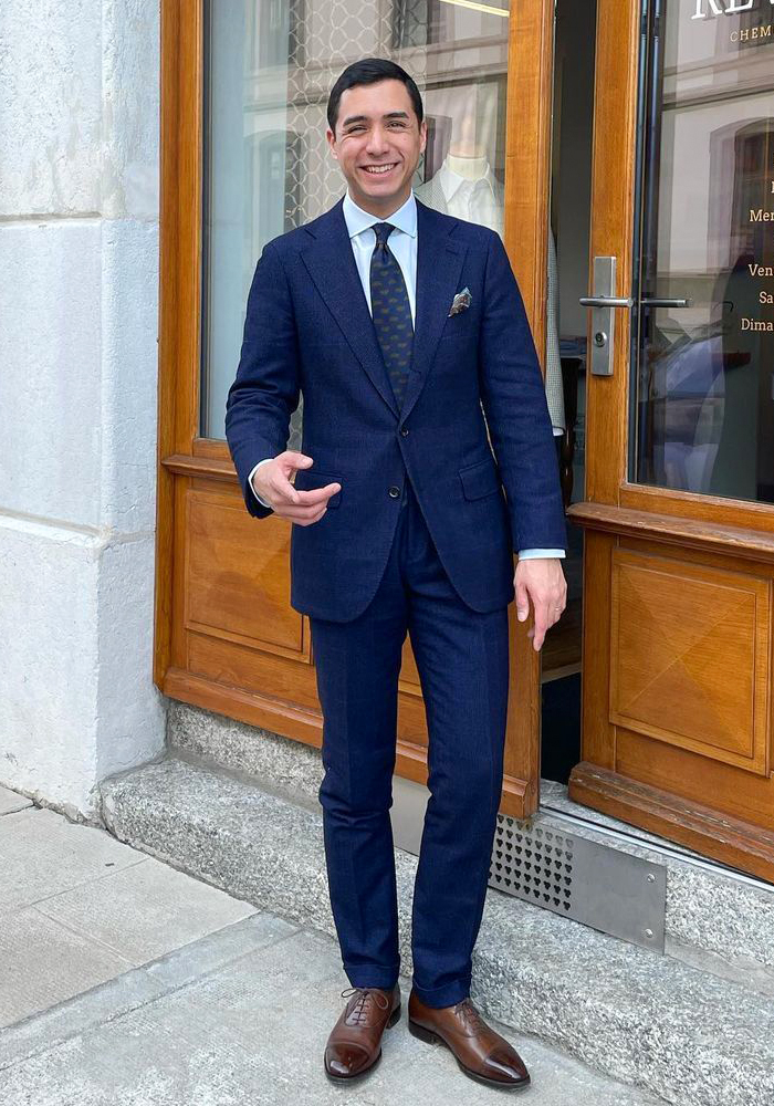 Blue suit, blue dress shirt, navy tie, and brown oxford shoes