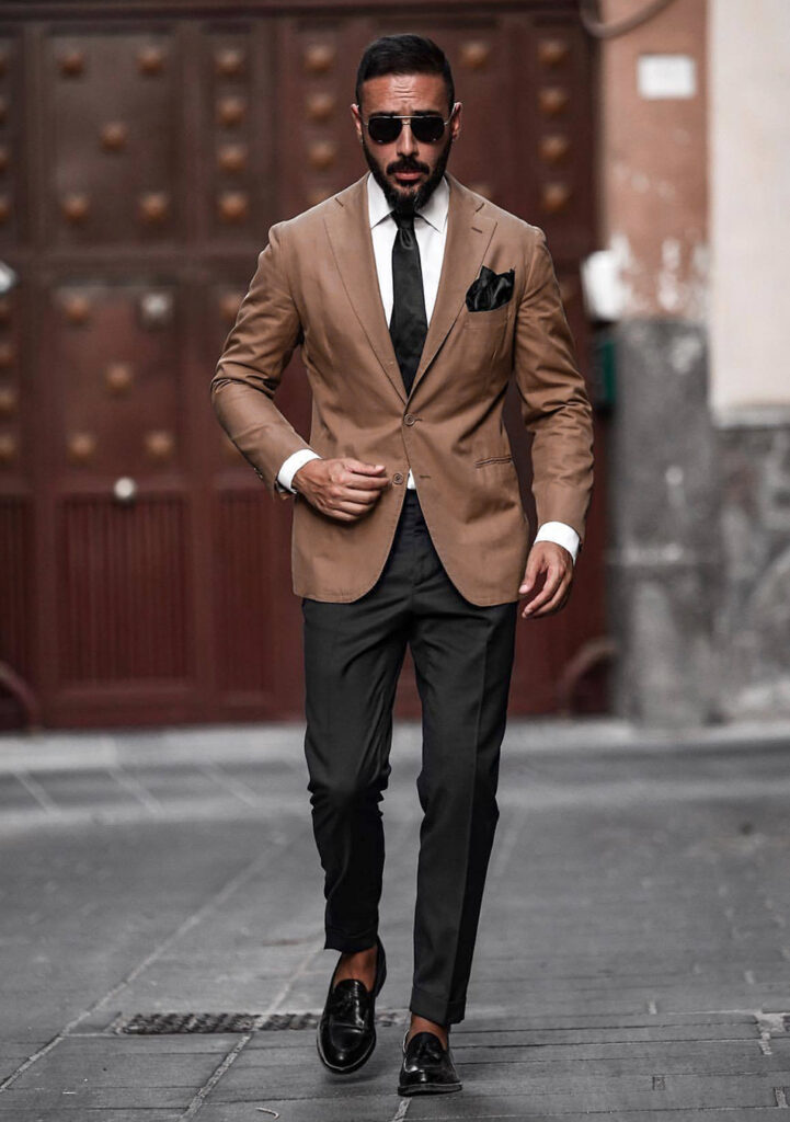 Brown blazer with black pants, tie, and loafers