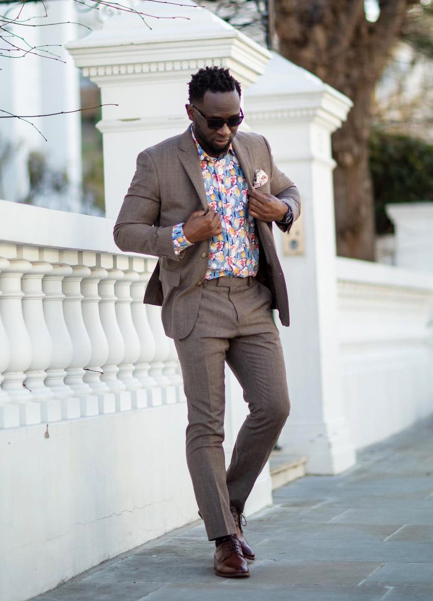 Light brown suit, blue printed floral shirt, and brown derby shoes