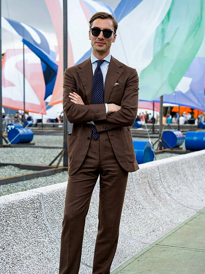 Brown suit, light blue striped shirt, and navy dotted tie