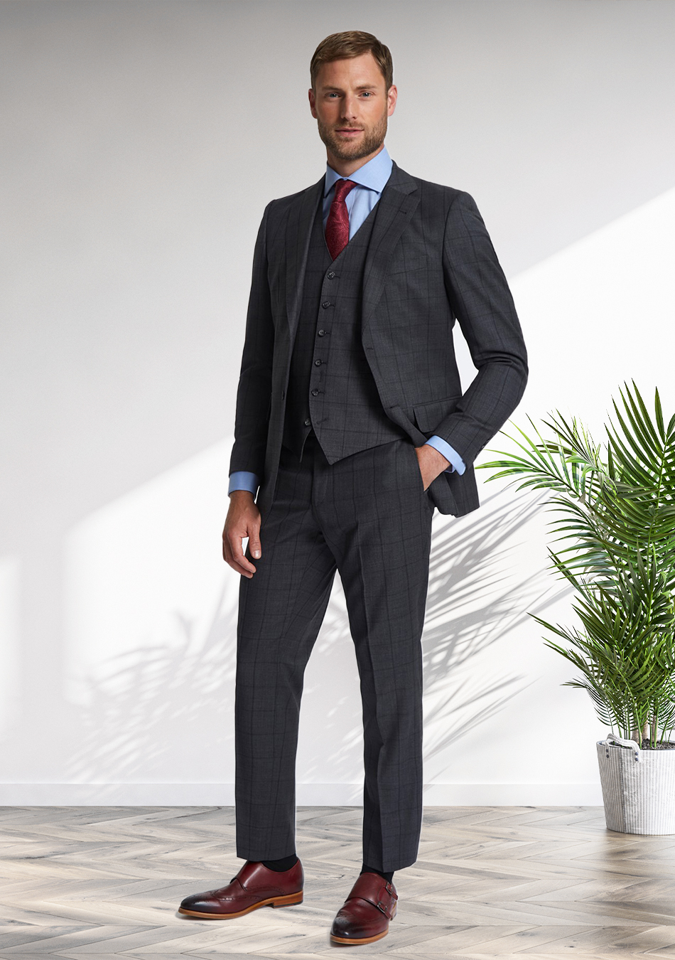 Charcoal grey three-piece suit, blue dress shirt, and burgundy monk straps