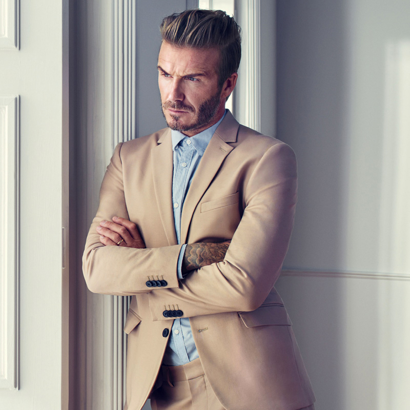 David Beckham wearing a tan suit with light blue shirt