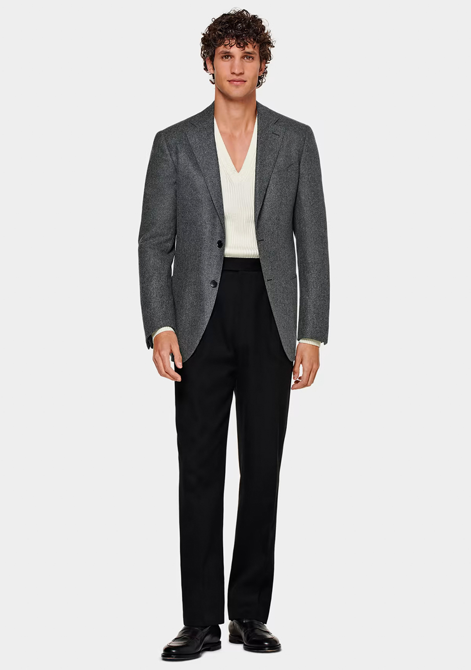 Grey blazer, off-white v neck sweater, black pleated pants, and black penny loafers