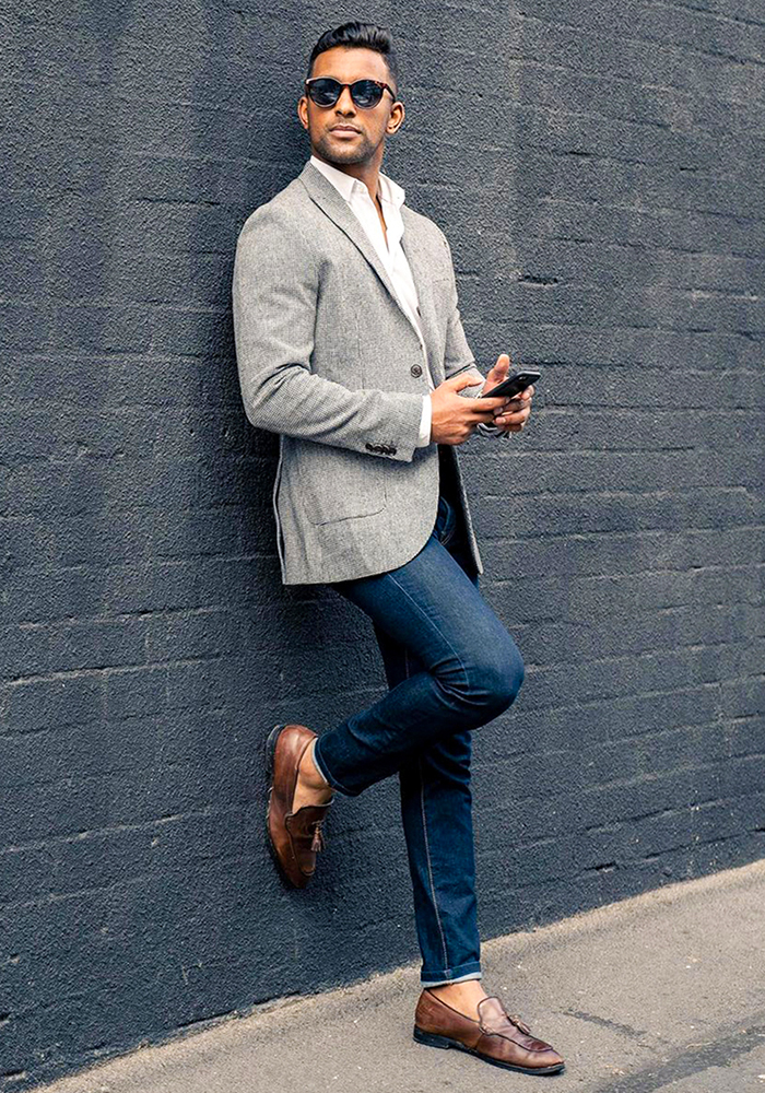 Grey blazer, white dress shirt, dark blue jeans, and brown loafers