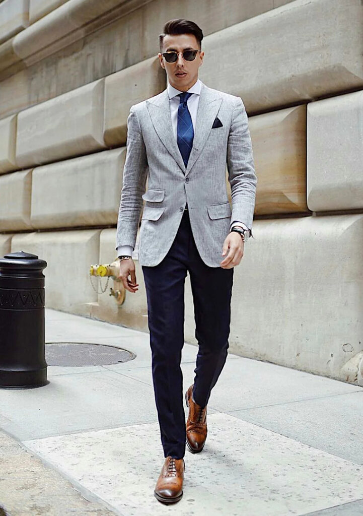 grey blazer white shirt blue tie black panst and brown oxford shoes