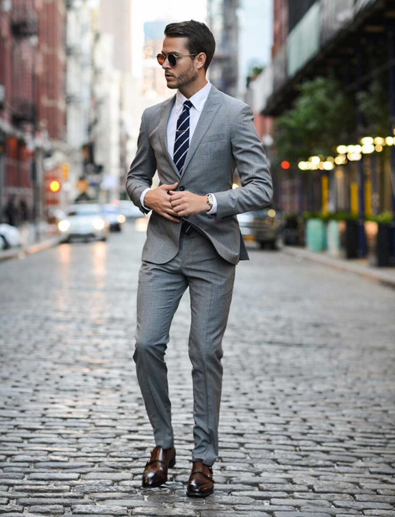 Grey suit, white shirt, navy striped tie, and brown dress shoes