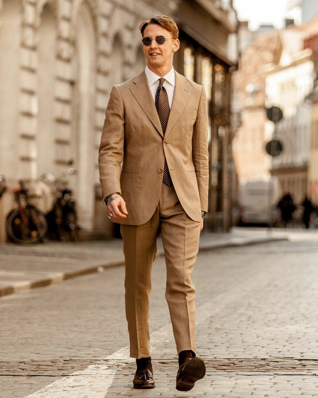 Formally wearing a khaki suit with brown dress shoes