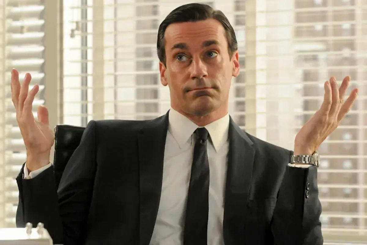 Don Draper in Mad Men wearing a classic black suit and black tie as a formal business outfit