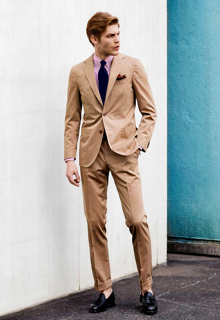 Khaki suit with a light pink striped shirt, navy tie and black loafers