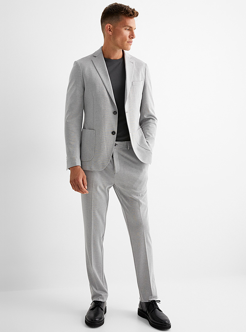 Light gray suit, black t-shirt, and black derby shoes