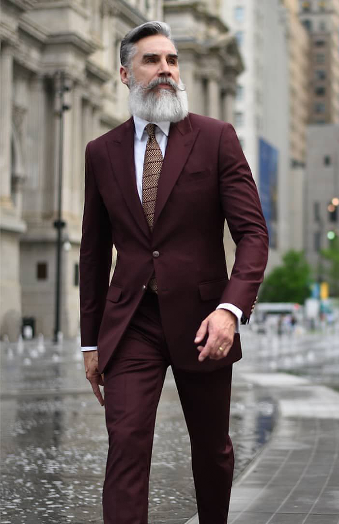 Maroon Suit with a white dress shirt and brown striped tie