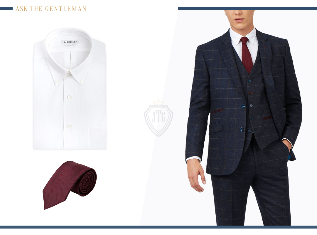 Matching a navy blue suit with a white dress shirt and a burgundy tie