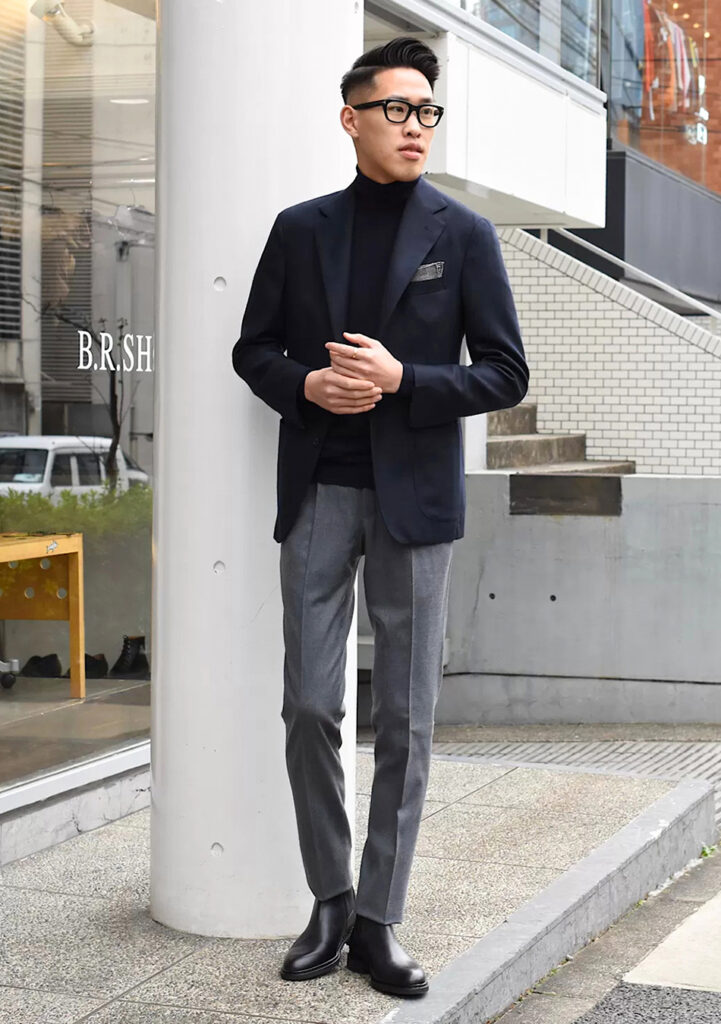 Navy blazer, grey pants, black turtleneck, and black Chelsea boots