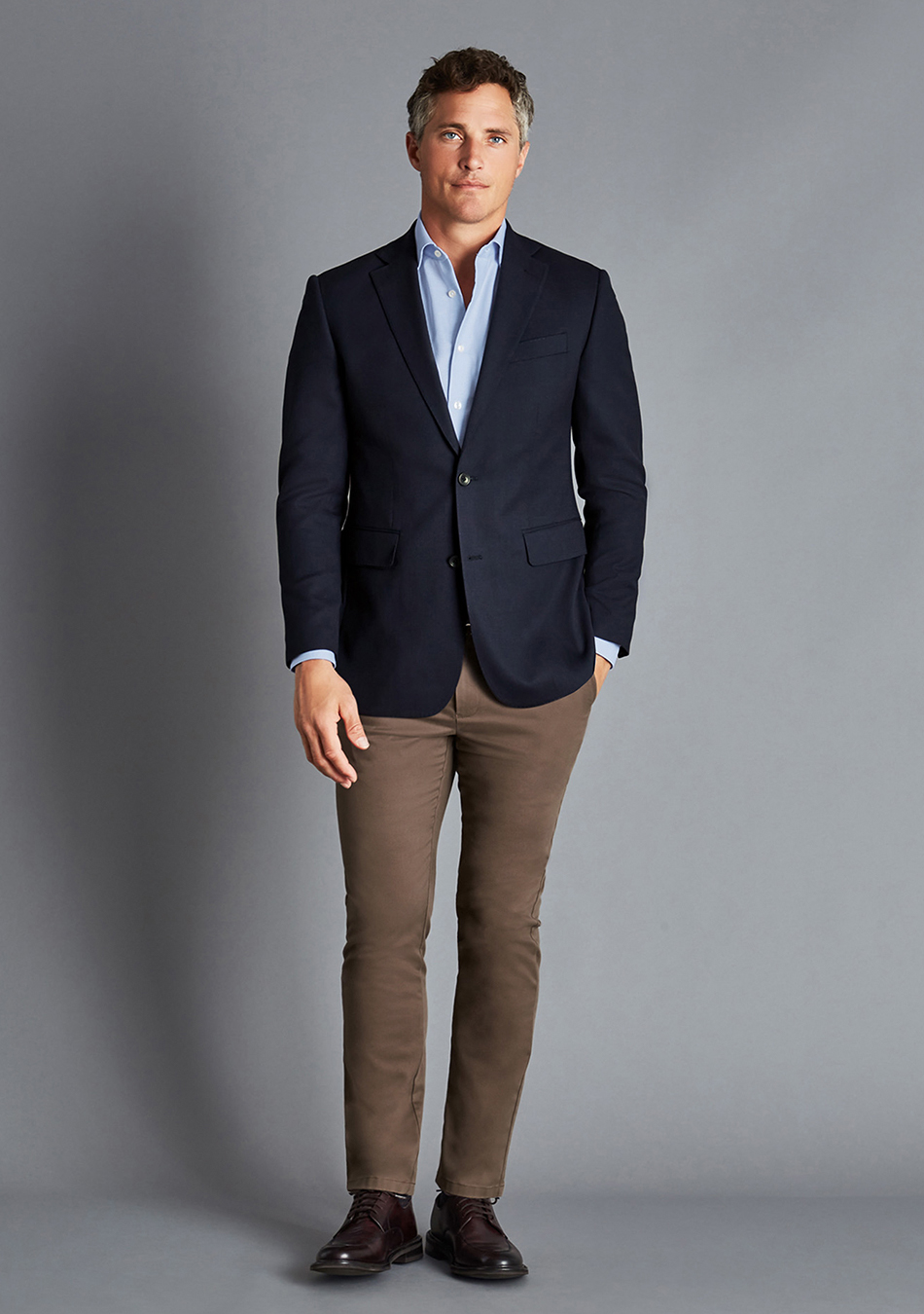 Navy blazer, light blue dress shirt, brown jeans, and brown derby shoes