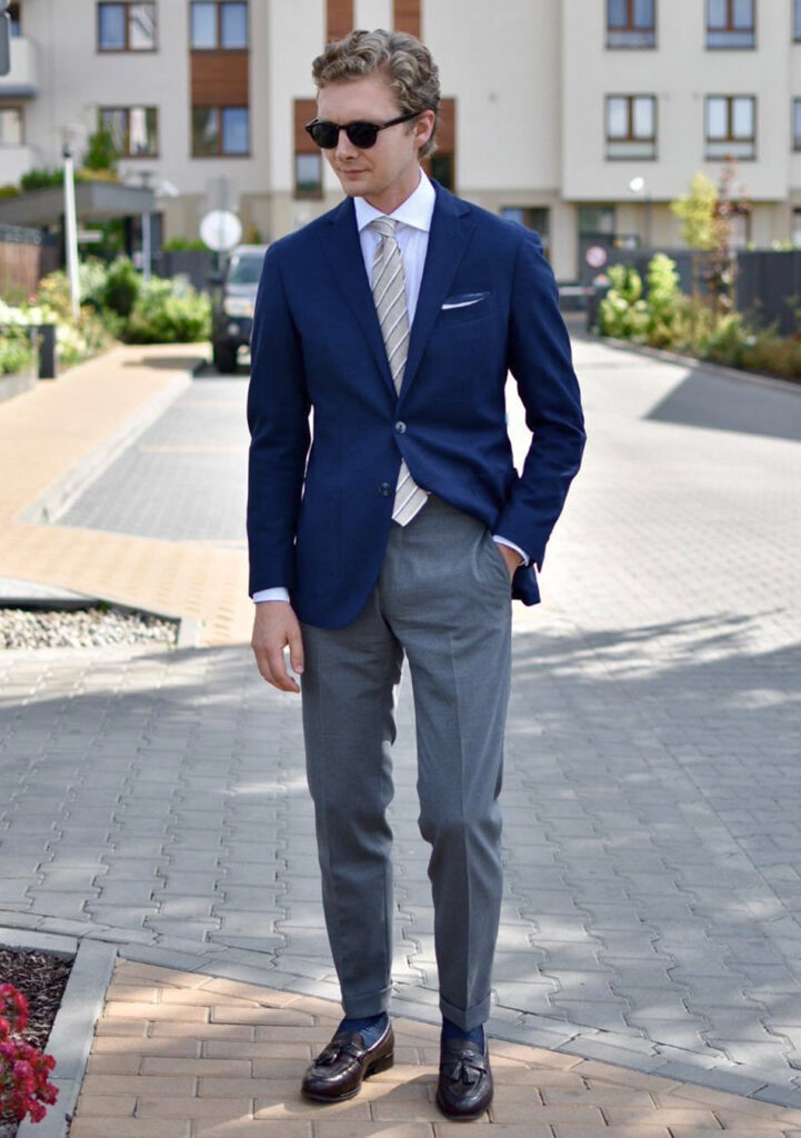 Navy blue blazer, white shirt, grey pants, and brown loafers