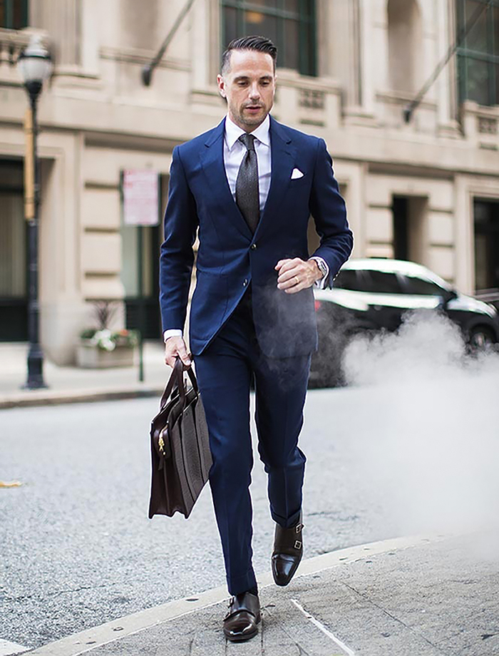 Navy blue cotton suit with a white dress shirt, brown tie, and dark brown shoes