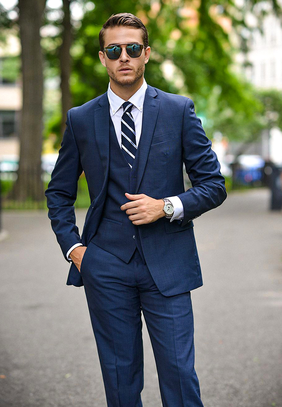 Navy blue three-piece suit, white shirt, and striped navy tie