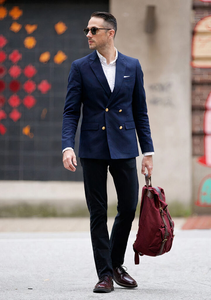 Navy double-breasted blazer, white shirt, black jeans, and burgundy derby shoes