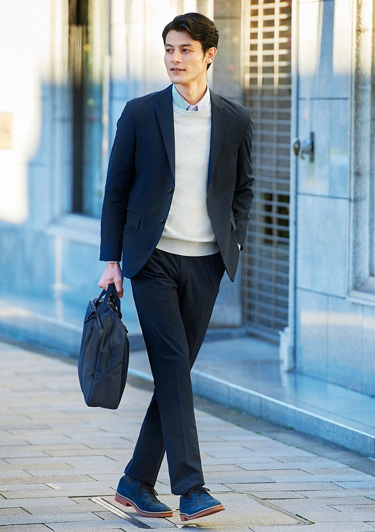 Navy suit, grey crew-neck sweater, white and navy striped dress shirt, and navy suede brogues