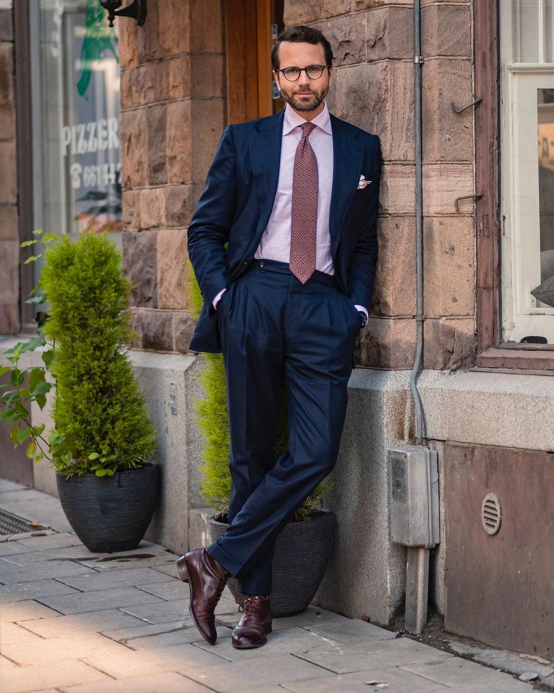 Navy suit, pink shirt, and dark red foulard tie