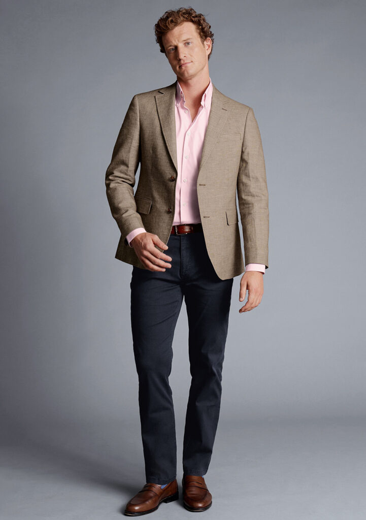 Tan blazer, pink dress shirt, navy jeans, and brown loafers