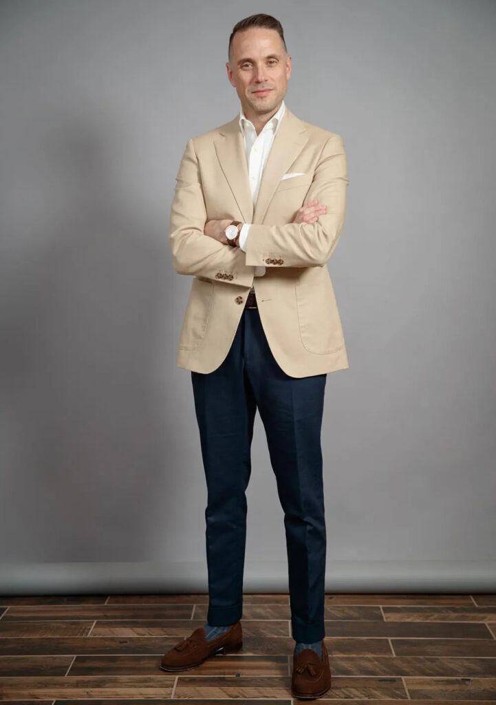 Tan blazer, white shirt, navy pants, and brown loafers