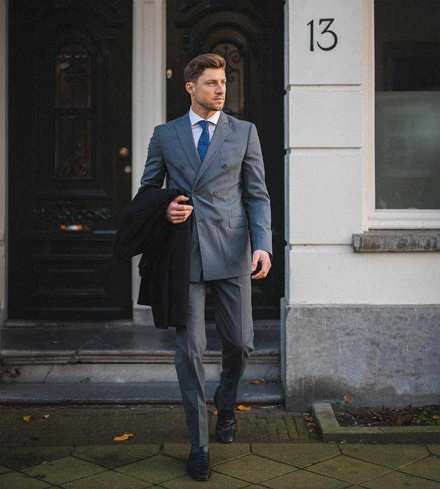 Wearing a double-breasted pinstripe suit with a white shirt and blue tie