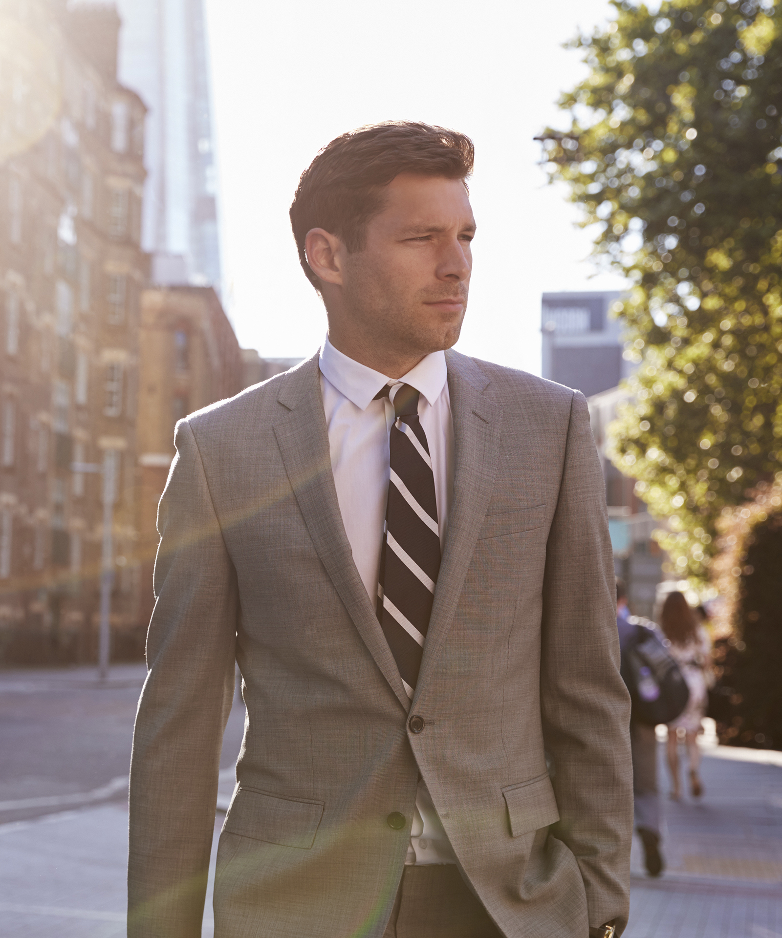 Wearing a grey suit with a striped charcoal/white tie in London
