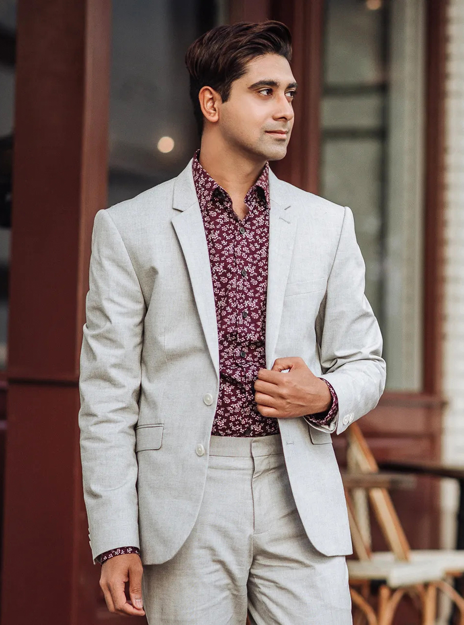 wearing a light grey suit with floral burgundy shirt