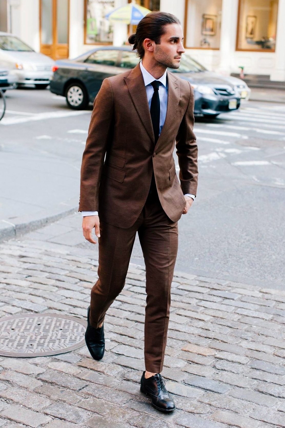 Wearing black dress shoes and a brown suit