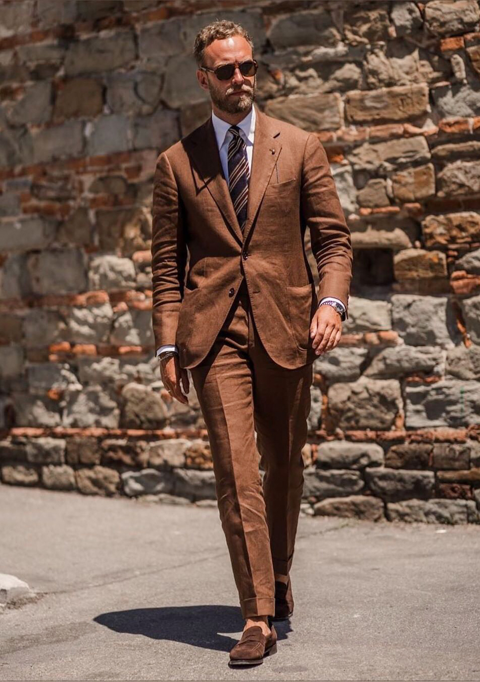 Wearing an earthy-tone brown suit with brown suede loafers