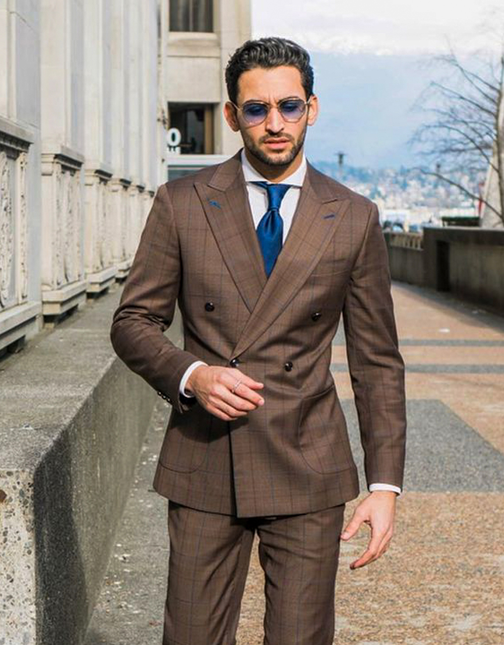 Wearing a double-breasted brown suit with a white shirt and navy blue tie