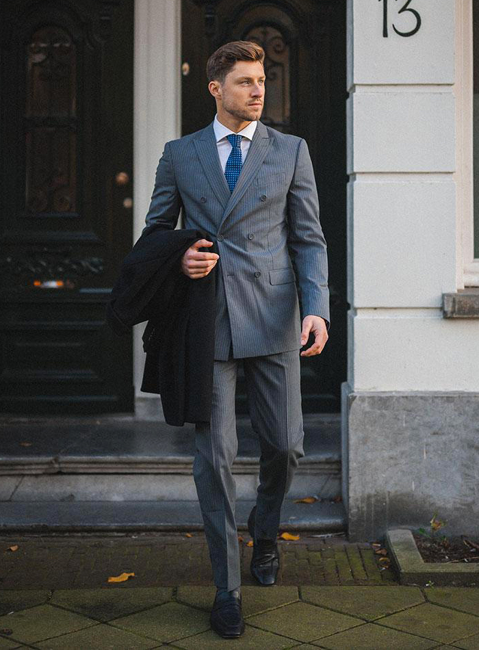 Wearing a double-breasted pinstripe grey suit