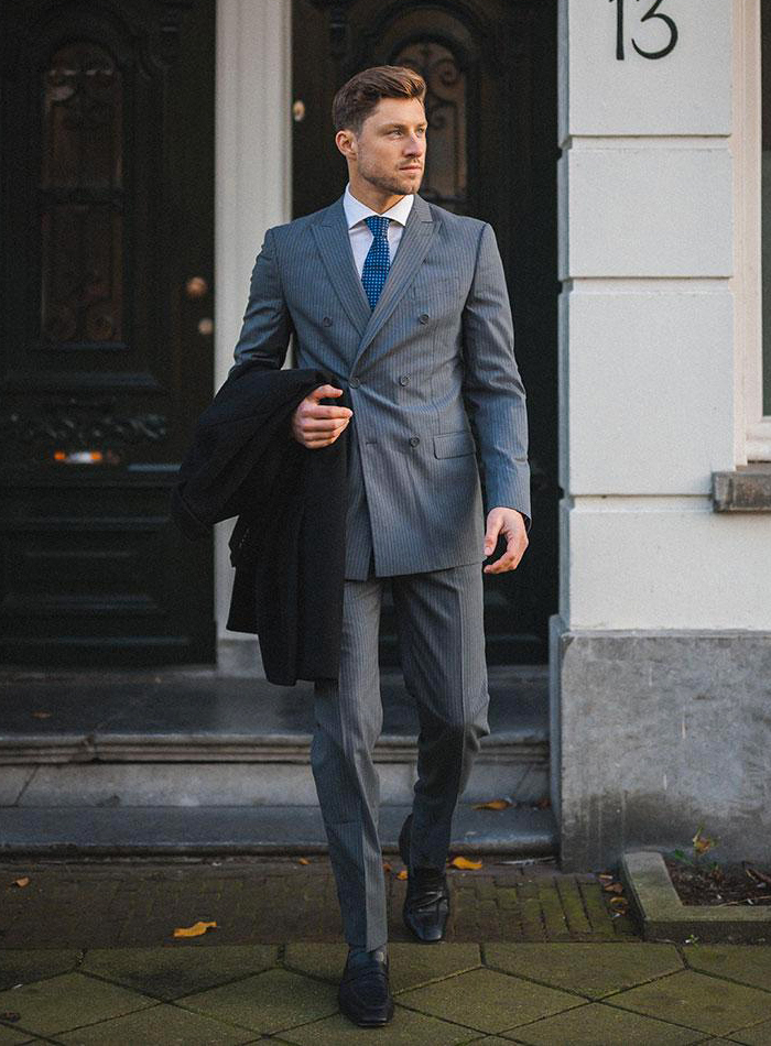 Wearing a double-breasted pinstripe suit with white shirt and blue tie