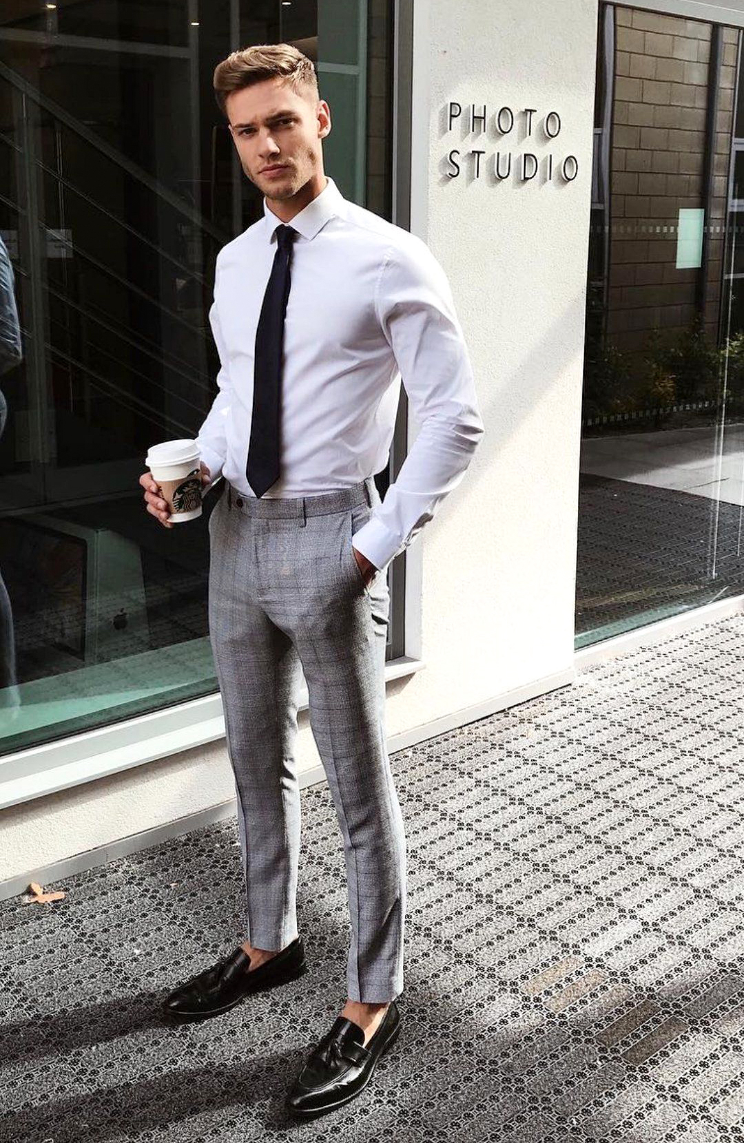 White dress shirt, grey pants, black tie, and black loafers